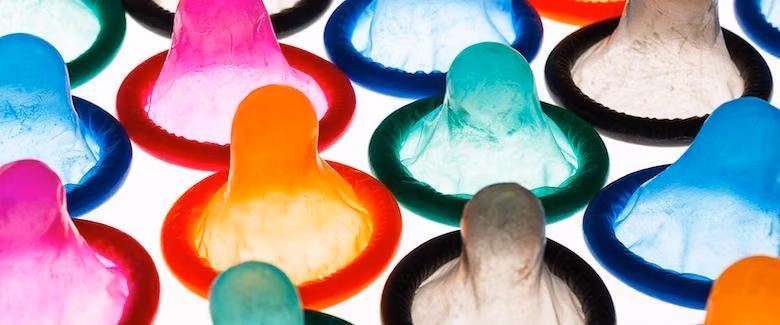 Rows of colorful unrolled condoms lit from behind