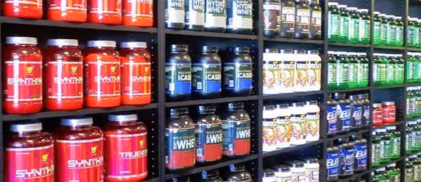Store shelves lined with tubs of whey protein, casein and other workout supplements