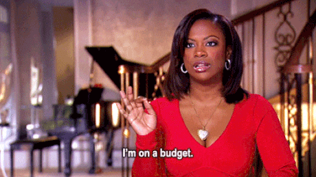A woman in red waves her hand and says "I'm on a budget"