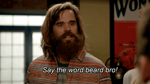 Long-haired bearded man in a patterned shirt saying, "Say the word beard bro!"