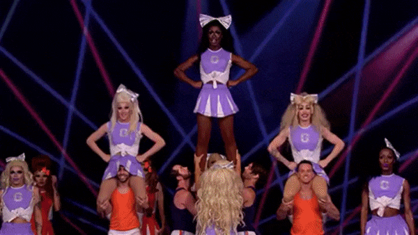 Queens in purple cheerleader uniforms build a pyramid during the cheerleading challenge