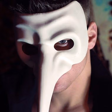 Close-up of a man in a white long-nosed mask from Black Spark's films