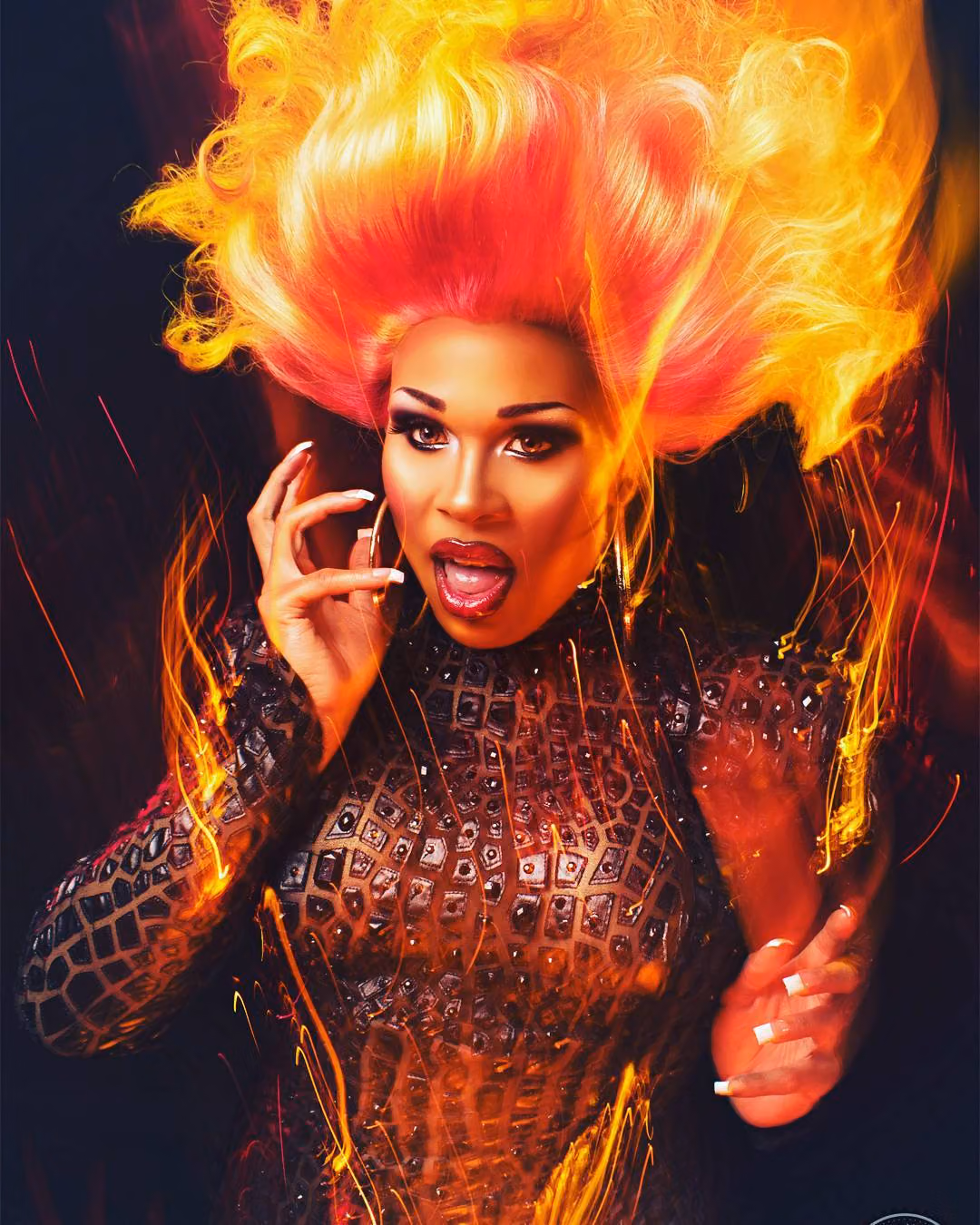 Peppermint in a flame-colored wig and studded black bodysuit, surrounded by fiery light streaks