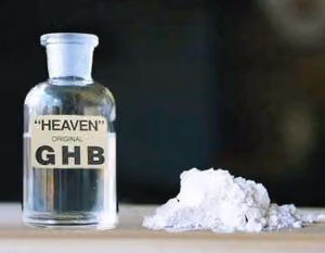 Glass bottle of clear liquid labeled "Heaven Original GHB" next to a small pile of white powder