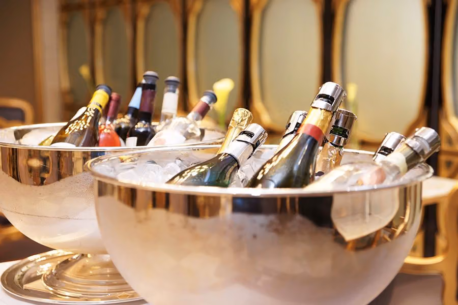 Bottles of sparkling wine chilling in two silver ice buckets