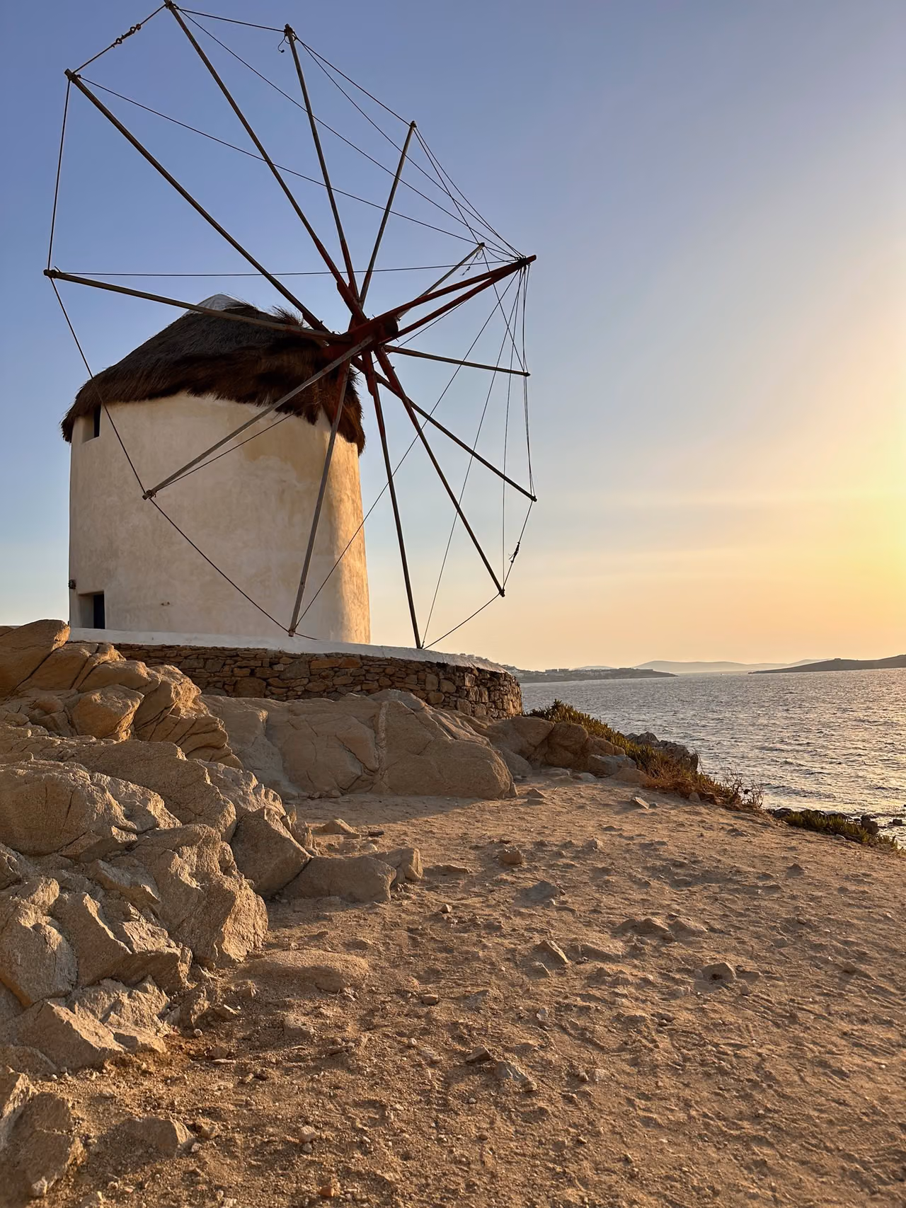 A white Mykonos windmill against the evening sky.