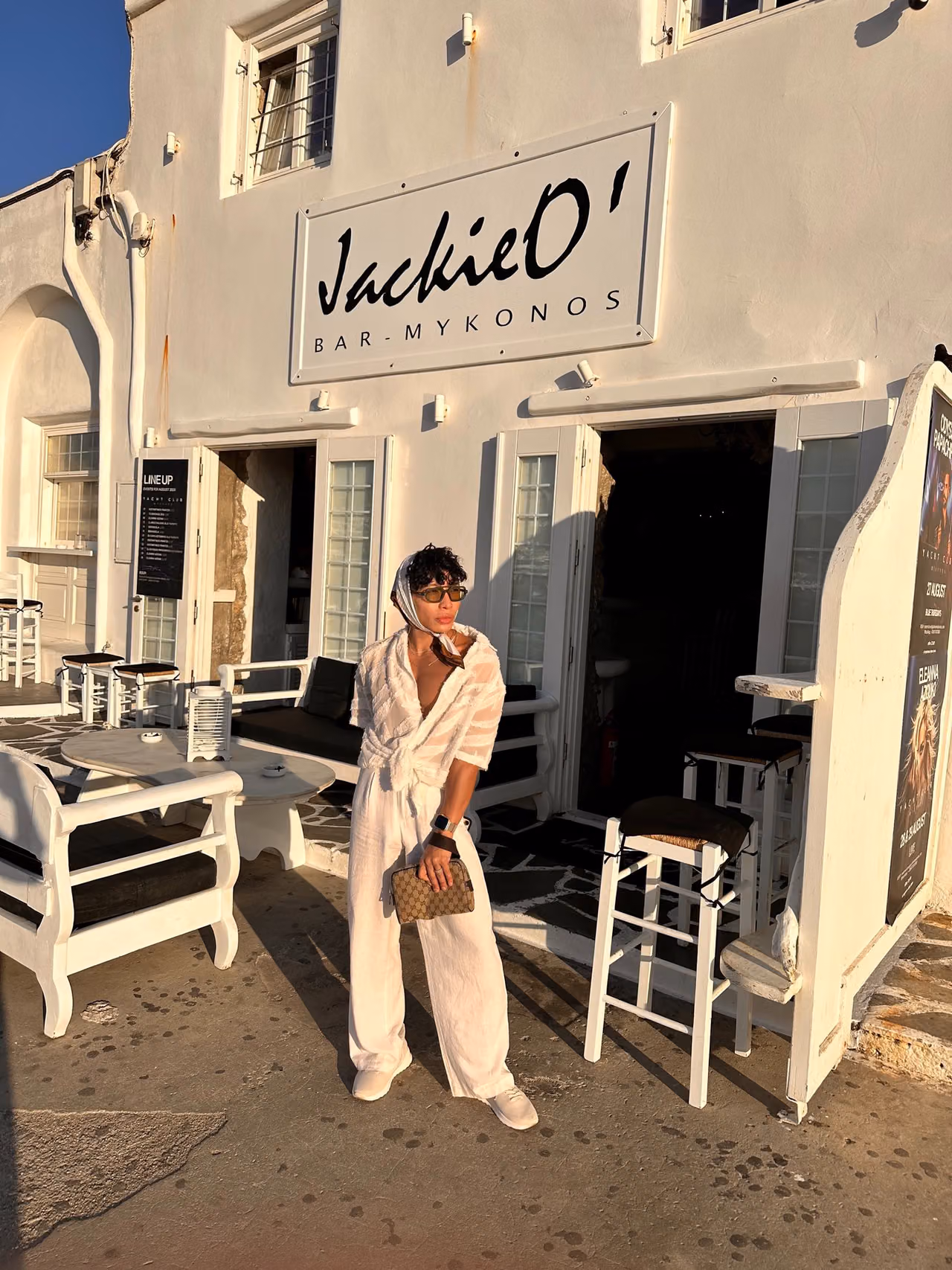 Beatus standing beside the Jackie O’s Town Bar sign during the day.