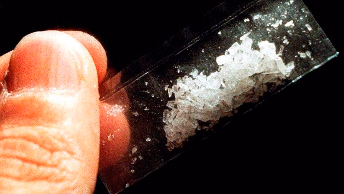 Fingers holding a small baggie of white crystal drugs, illustrating the drug use shown in Queer As Folk