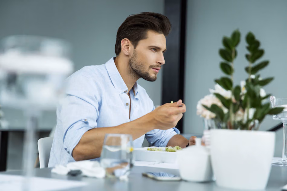 Man eating a small plate of food at a restaurant table