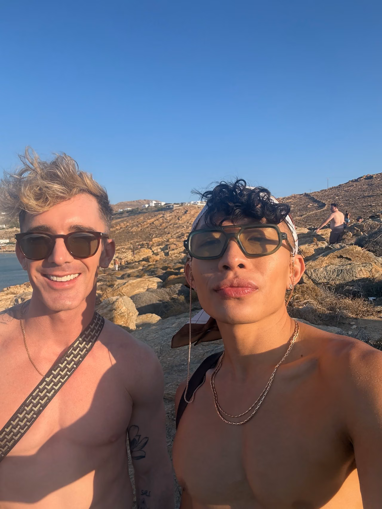 Mark and Beatus taking a selfie beside the clear water at Elia Beach.