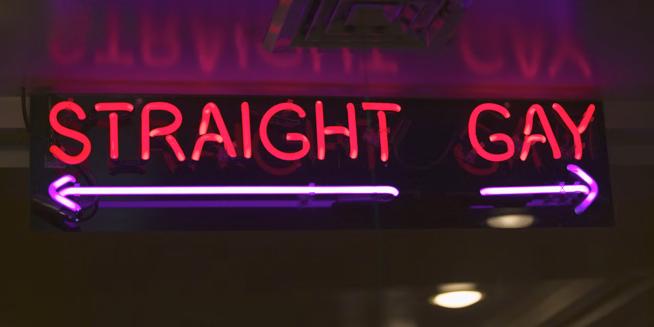 Neon signs reading "Straight" and "Gay" with arrows pointing opposite ways, a nod to sexualities between them