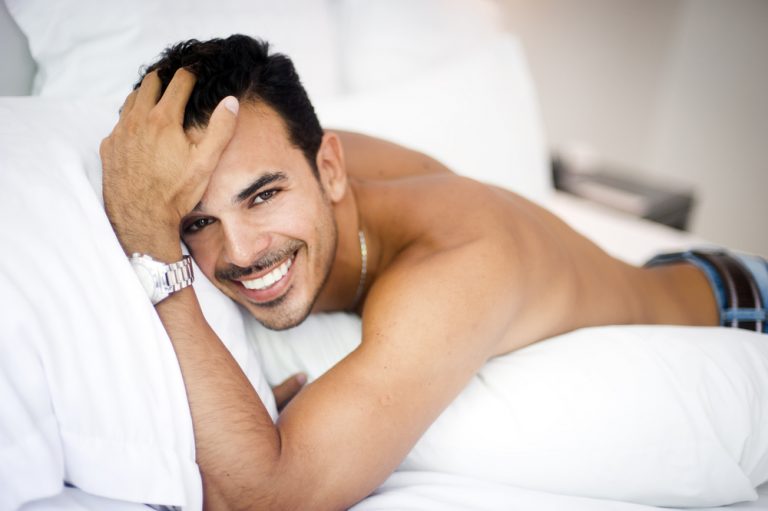 beautiful man laying on bed