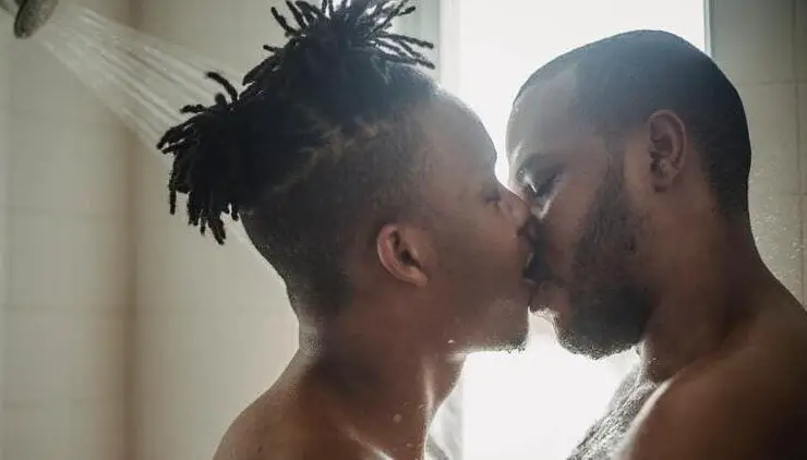 two gay black men kissing while in shower