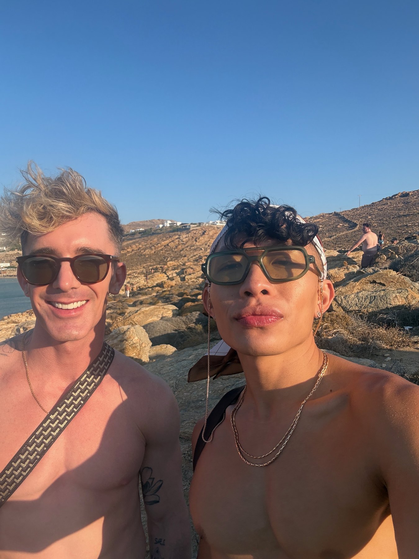 Mark and Beatus taking a selfie beside the clear water at Elia Beach.