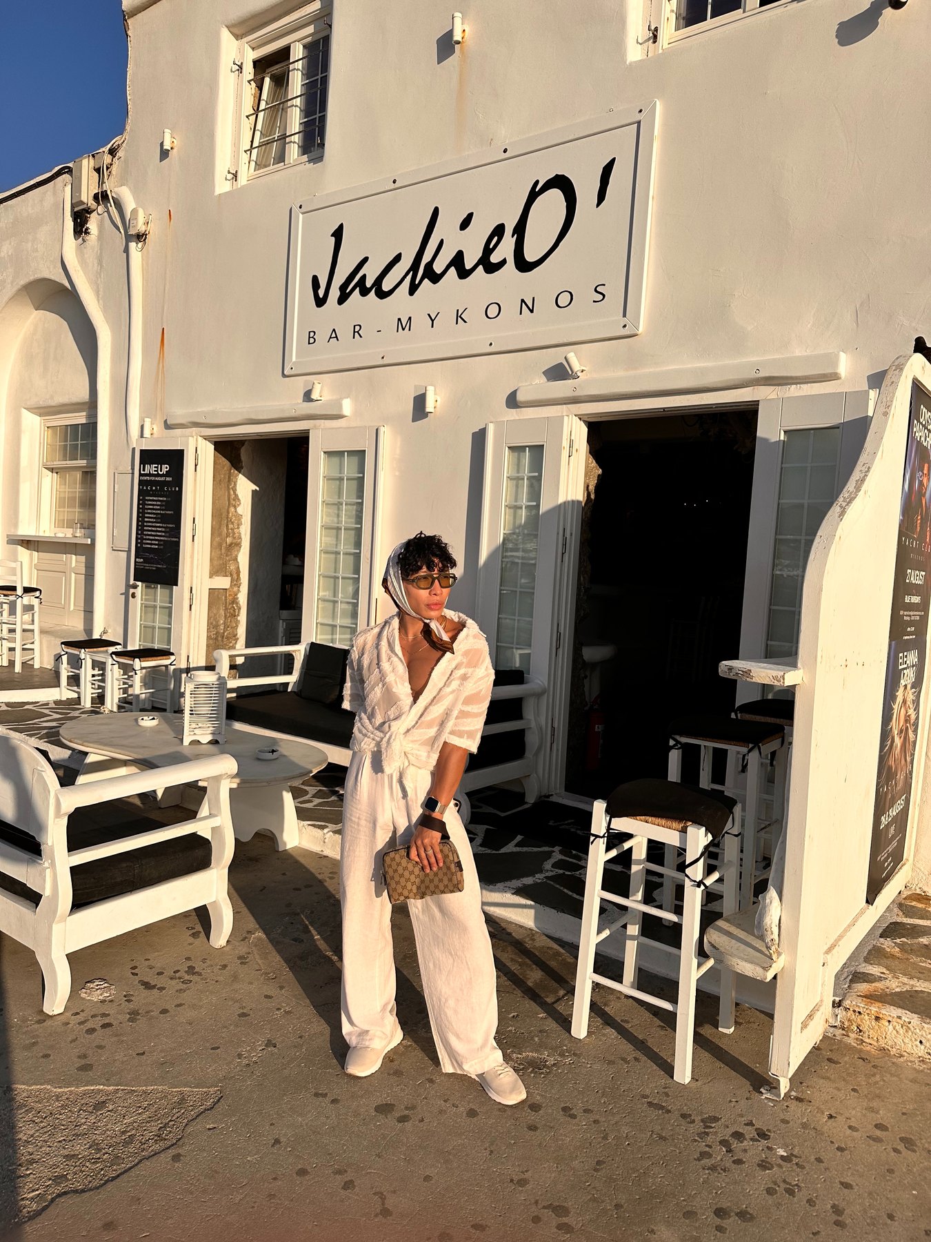 Beatus standing beside the Jackie O’s Town Bar sign during the day.