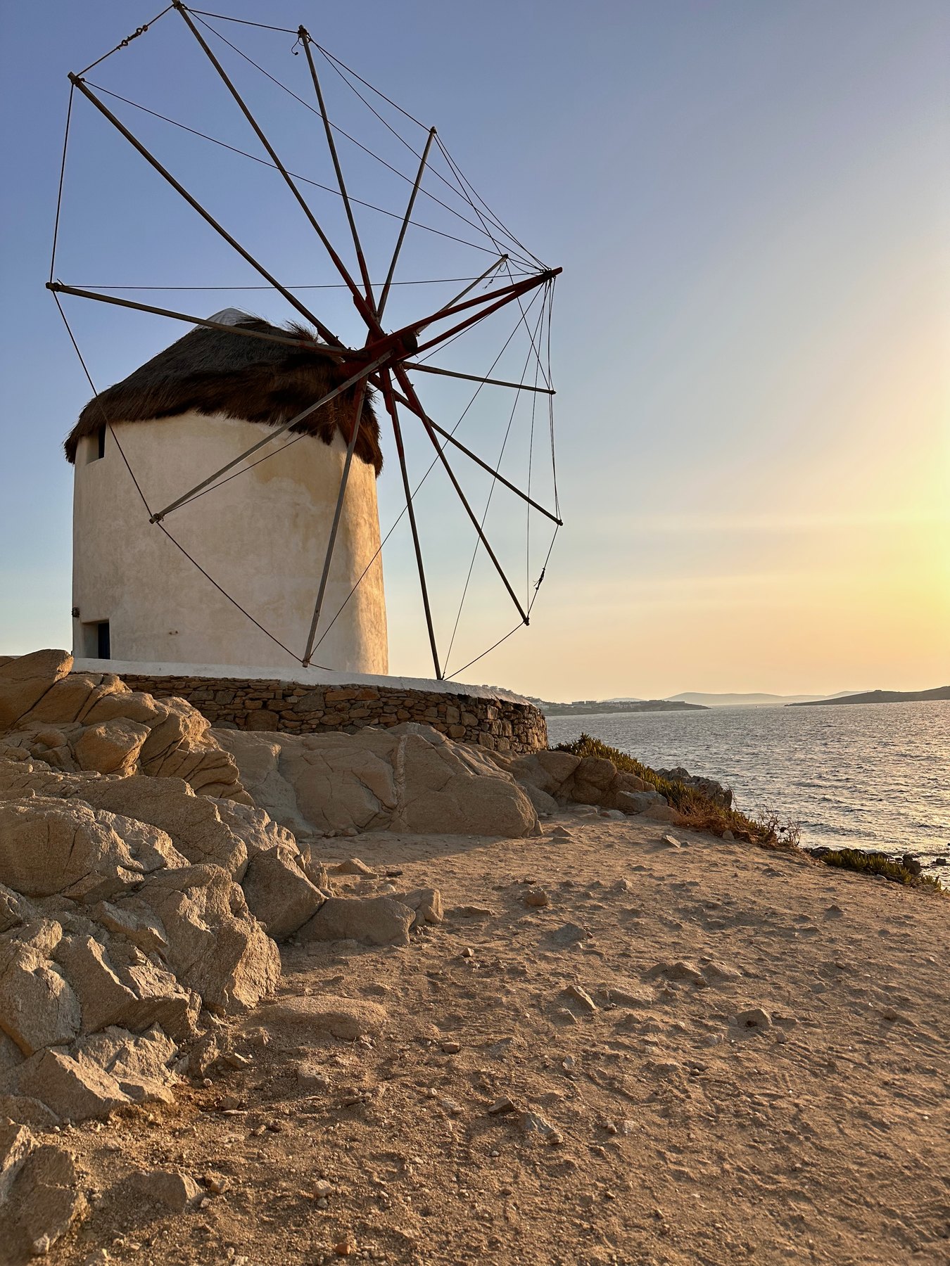 A white Mykonos windmill against the evening sky.